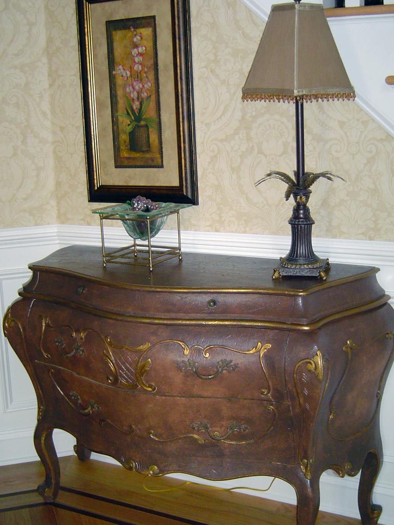 Bombe chest painted with brown glaze and gold accents.