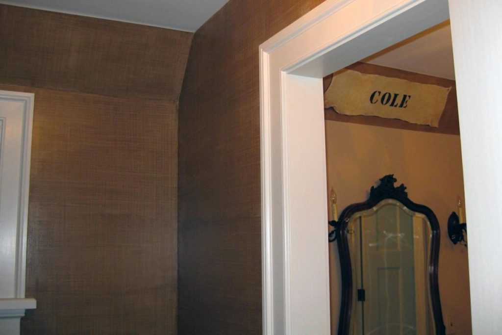 Brown linen-weave glaze painted in bathroom, with parchment-finish name banner painted above sink.