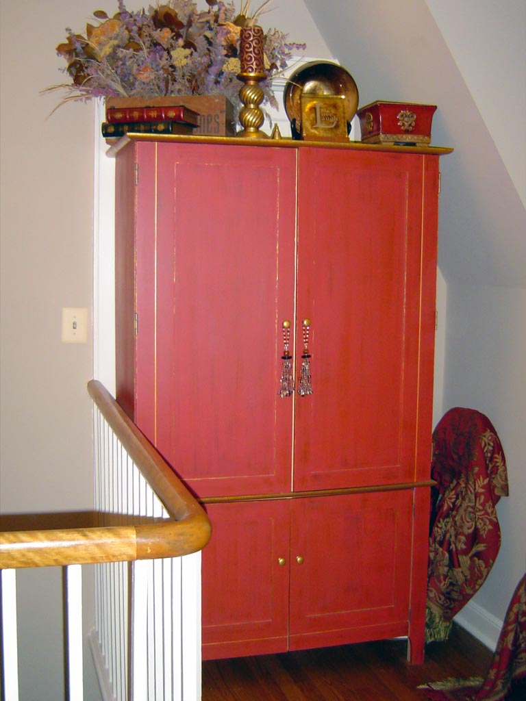 Maple computer armoire painted in a rustic red with dry-brushed glaze and gold accents.