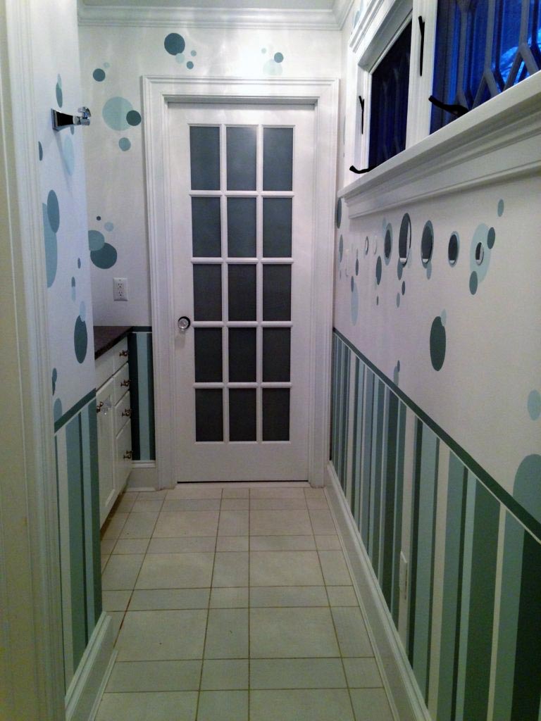 A palette of ocean greens painted in stripes and circles in this girl’s bathroom.