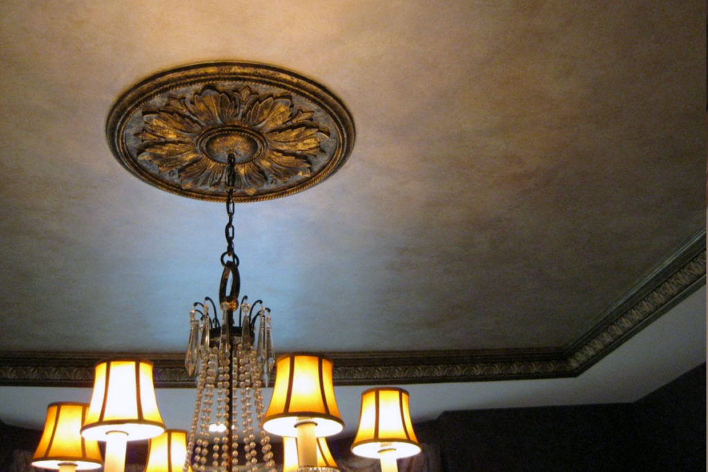 Warm gold/silver paint treatment on the Dining Room tray ceiling, and antique bronze finish on crown molding and chandelier plaque.