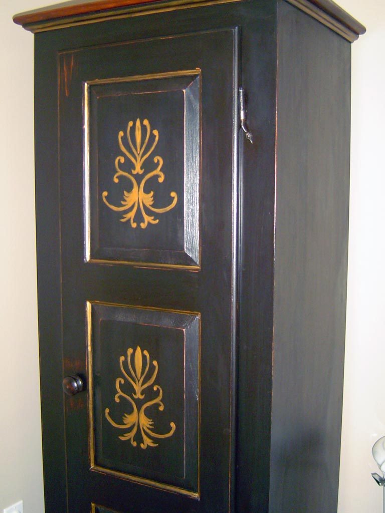 Storage cabinet painted with custom stenciled and hand-painted gold details.