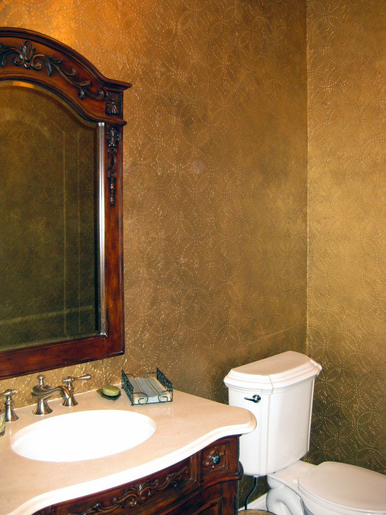 Dimensional plaster stencil design applied in powder room, then painted with an antique metallic gold finish.