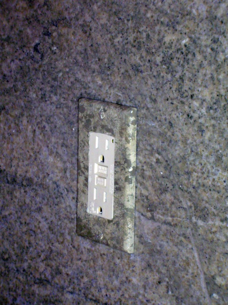 Outlet plates painted to blend into the granite backsplash.