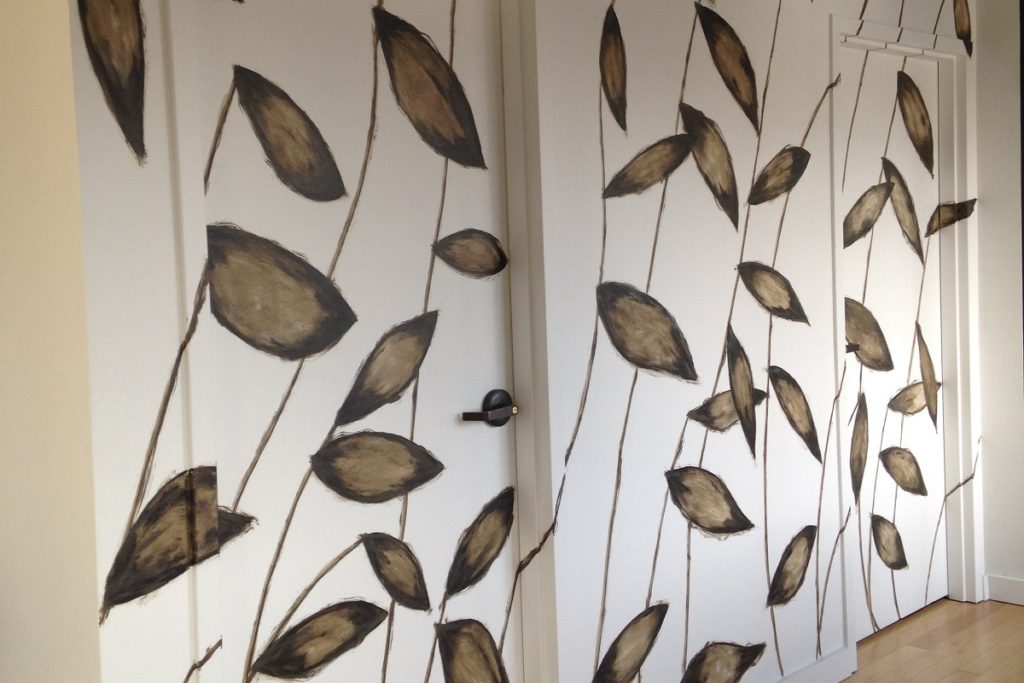 Large graphic leaf design camouflages the doors in this hallway.