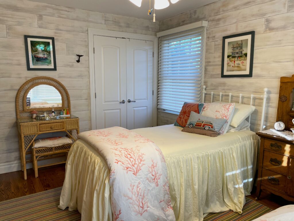 Guest bedroom painted with whimsical drybrush planking for a beachy cabana look.